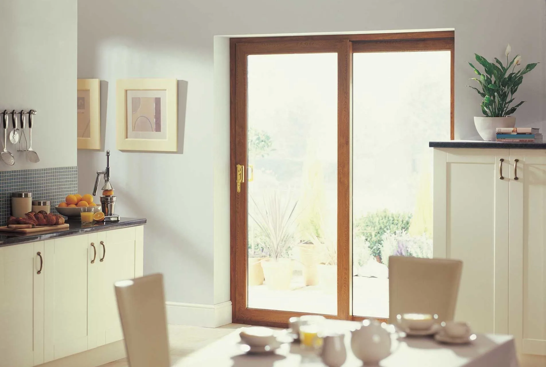 Golden-oak effect uPVC sliding patio door in a cream kitchen diner